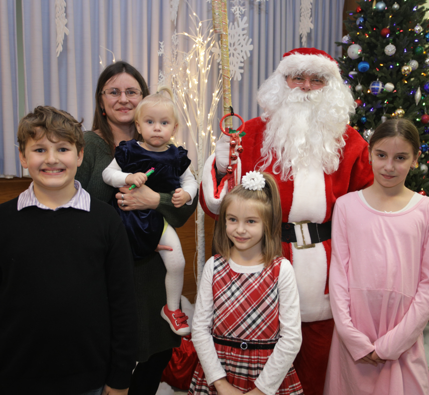 Four children with mom meeting Santa Claus